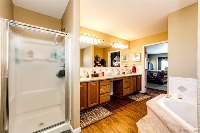 bathroom featuring decorative backsplash, vanity, shower with separate bathtub, and hardwood / wood-style flooring