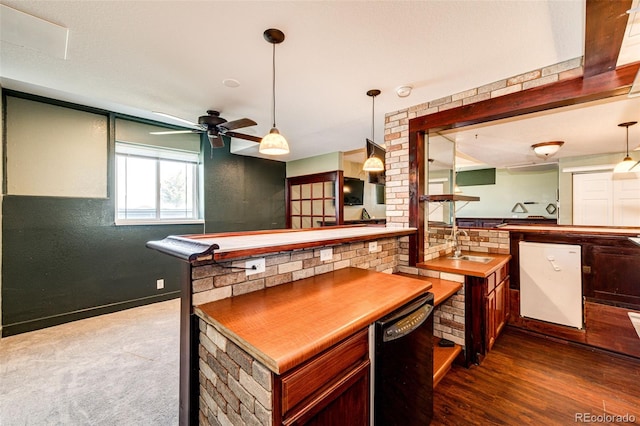 bar with hanging light fixtures, ceiling fan, black dishwasher, wood-type flooring, and brick wall