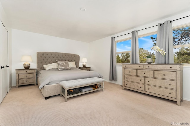 bedroom with baseboards, multiple windows, and light carpet