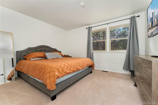 bedroom featuring baseboards, visible vents, and light colored carpet