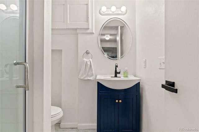 full bath with an enclosed shower, vanity, baseboards, and toilet