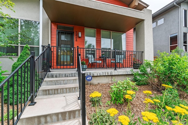 2868 Kingston St, Denver, CO 80238 - doorway to property with covered porch and stucco siding
