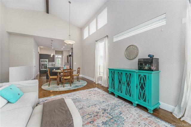 2868 Kingston St, Denver, CO 80238 - living area featuring wood finished floors, high vaulted ceiling, beam ceiling, and healthy amount of natural light