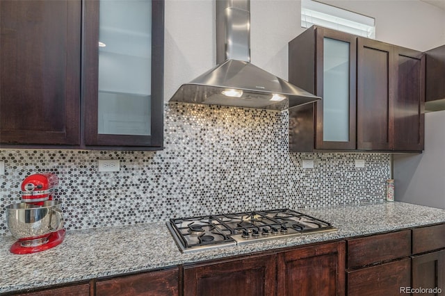 2868 Kingston St, Denver, CO 80238 - kitchen featuring wall chimney exhaust hood, stainless steel gas stovetop, dark brown cabinetry, and backsplash