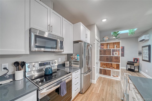 114 Old Stage Rd Unit D, Salida, CO 81201 - kitchen with stainless steel appliances, a wall unit AC, light wood finished floors, white cabinets, and recessed lighting