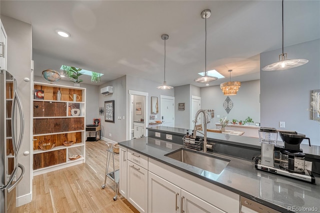 114 Old Stage Rd Unit D, Salida, CO 81201 - kitchen with a sink, freestanding refrigerator, a wall mounted AC, dark countertops, and white cabinets