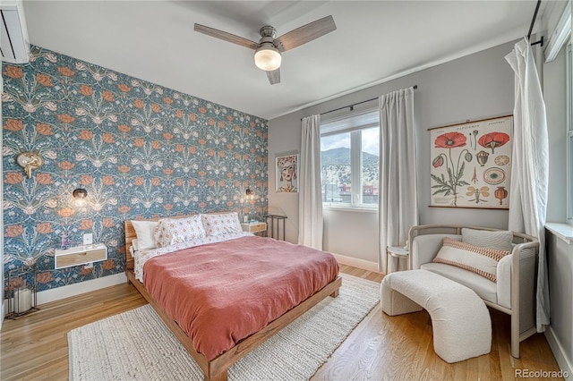 114 Old Stage Rd Unit D, Salida, CO 81201 - bedroom with baseboards, wood finished floors, wallpapered walls, and a ceiling fan