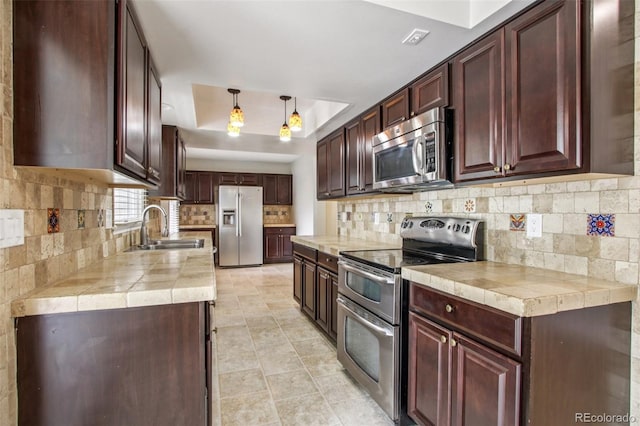 2518 S Dawson Way, Aurora, CO 80014 - kitchen featuring stainless steel appliances, a raised ceiling, tasteful backsplash, light tile patterned floors, and hanging light fixtures