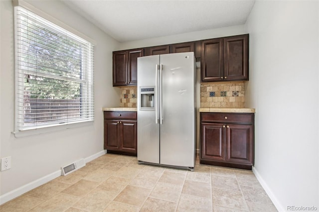 2518 S Dawson Way, Aurora, CO 80014 - kitchen featuring stainless steel fridge with ice dispenser, tasteful backsplash, and healthy amount of natural light