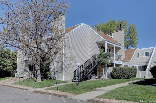 13633 E Yale Ave Unit B, Aurora, CO 80015 - view of front of property featuring a chimney, stairs, and a front lawn