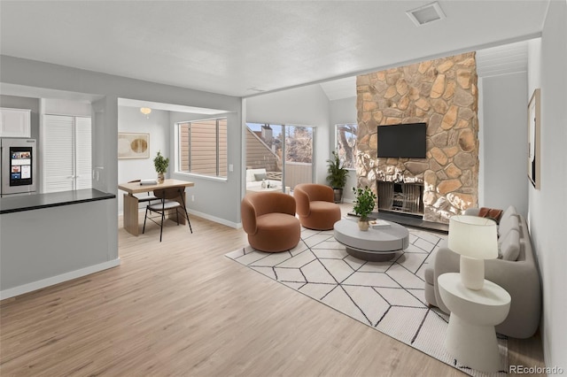 13633 E Yale Ave Unit B, Aurora, CO 80015 - living room with light wood-style flooring, a fireplace, and baseboards