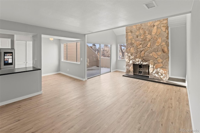 13633 E Yale Ave Unit B, Aurora, CO 80015 - unfurnished living room featuring wood finished floors, a fireplace, baseboards, stairs, and lofted ceiling