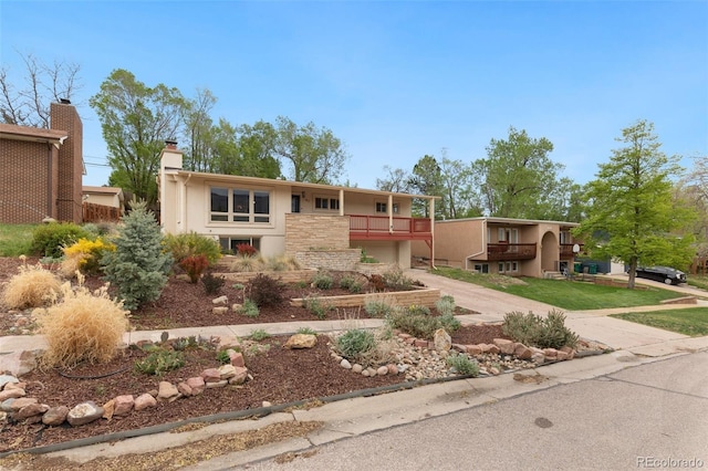 813 Panorama Dr, Colorado Springs, CO 80904 - view of front of property with a balcony, driveway, stucco siding, an attached garage, and a chimney