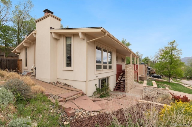 813 Panorama Dr, Colorado Springs, CO 80904 - view of property exterior with a chimney, stucco siding, and stairs