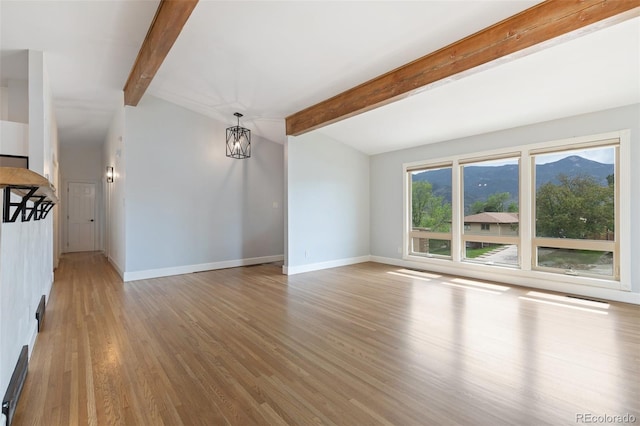 813 Panorama Dr, Colorado Springs, CO 80904 - unfurnished living room featuring light wood-style floors, baseboards, beamed ceiling, and a mountain view
