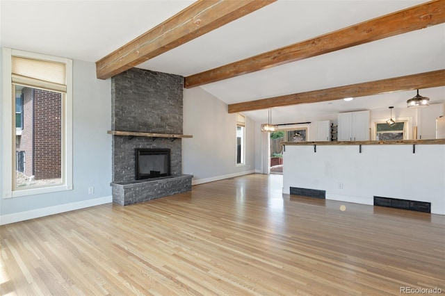 813 Panorama Dr, Colorado Springs, CO 80904 - unfurnished living room featuring light wood-style flooring, baseboards, a fireplace, and beam ceiling