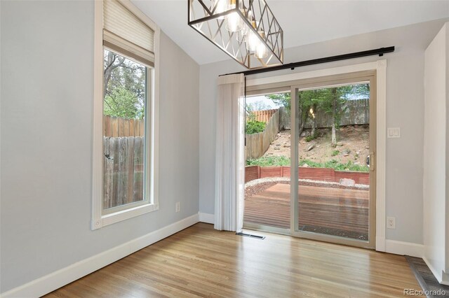813 Panorama Dr, Colorado Springs, CO 80904 - unfurnished dining area featuring healthy amount of natural light, baseboards, wood finished floors, and vaulted ceiling