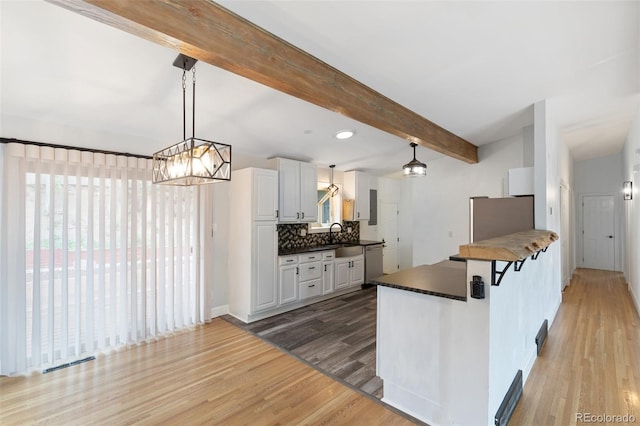 813 Panorama Dr, Colorado Springs, CO 80904 - kitchen featuring stainless steel dishwasher, refrigerator, light wood-style flooring, beam ceiling, and tasteful backsplash
