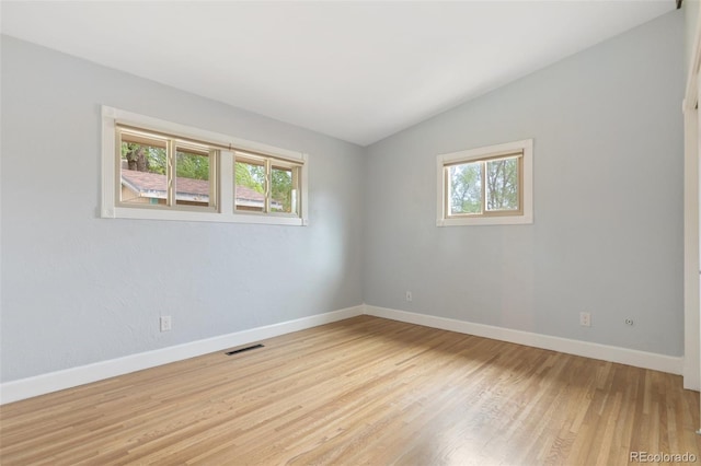 813 Panorama Dr, Colorado Springs, CO 80904 - spare room featuring healthy amount of natural light, lofted ceiling, light wood-type flooring, and baseboards