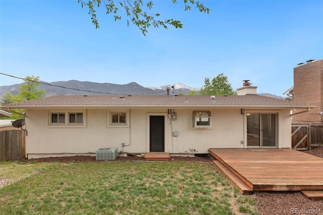 813 Panorama Dr, Colorado Springs, CO 80904 - rear view of property featuring a deck with mountain view, stucco siding, central air condition unit, and a chimney