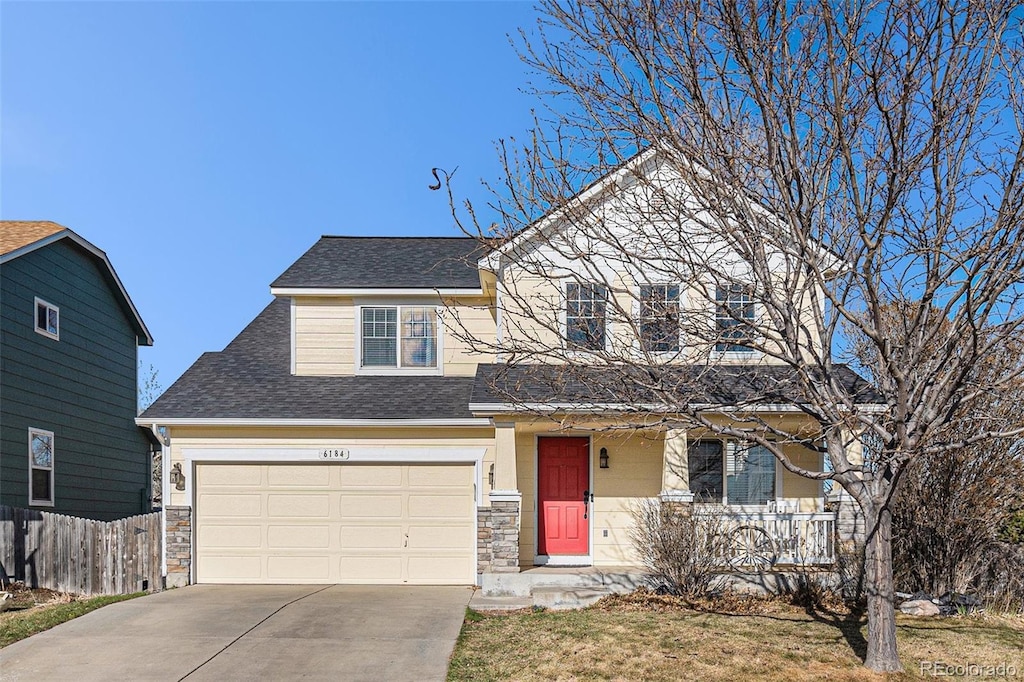 6184 Clayton St, Frederick, CO 80530 - traditional home featuring concrete driveway, stone siding, fence, a shingled roof, and covered porch