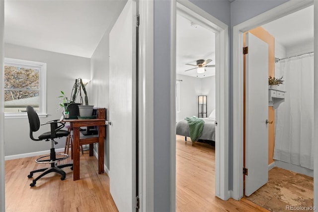 home office featuring light wood-type flooring and ceiling fan