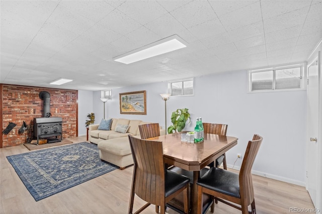 dining area with light wood-type flooring and a wood stove