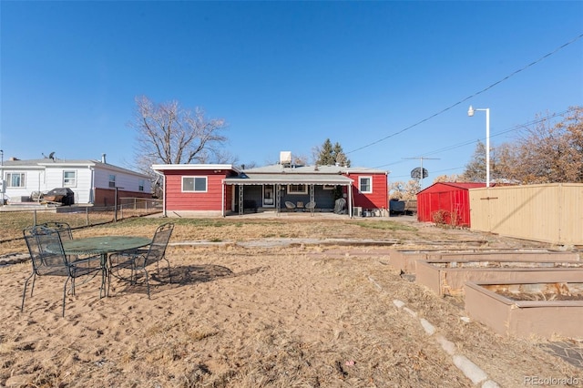 back of property featuring a storage unit