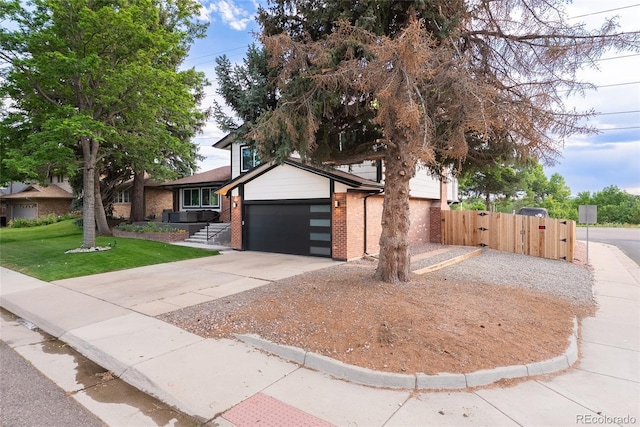 7302 E Bates Dr, Denver, CO 80231 - view of front of house featuring driveway, a gate, brick siding, and an attached garage