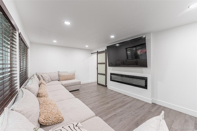 7302 E Bates Dr, Denver, CO 80231 - living room with a barn door, recessed lighting, and wood finished floors