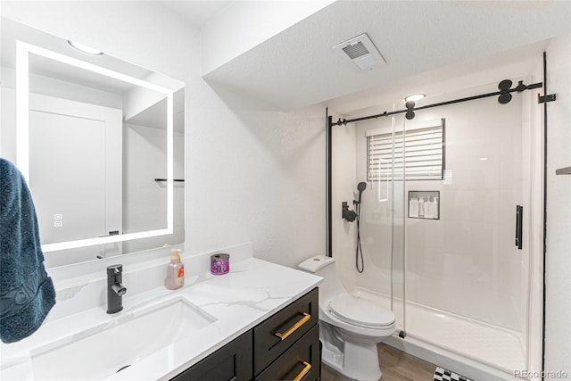 7302 E Bates Dr, Denver, CO 80231 - bathroom featuring vanity, a stall shower, and wood finished floors
