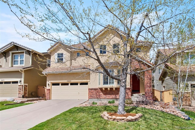 10633 Wynspire Way, Highlands Ranch, CO 80130 - view of front facade featuring stucco siding, brick siding, an attached garage, concrete driveway, and a front yard
