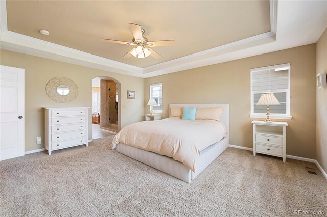 10633 Wynspire Way, Highlands Ranch, CO 80130 - carpeted bedroom with a tray ceiling, arched walkways, ensuite bath, and a ceiling fan