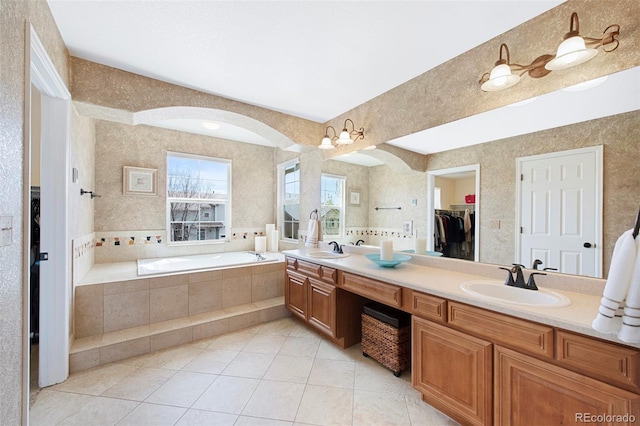 10633 Wynspire Way, Highlands Ranch, CO 80130 - full bath featuring double vanity, tile patterned flooring, a garden tub, a spacious closet, and wallpapered walls