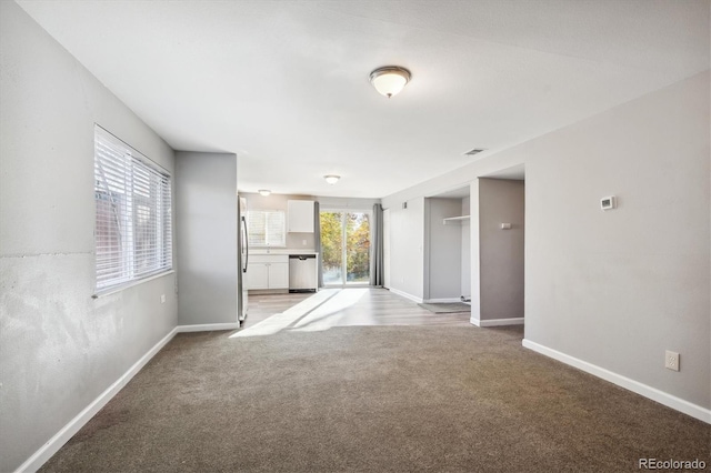 3900 Turnpike Dr, Westminster, CO 80030 - unfurnished living room with a healthy amount of sunlight, baseboards, visible vents, and light colored carpet