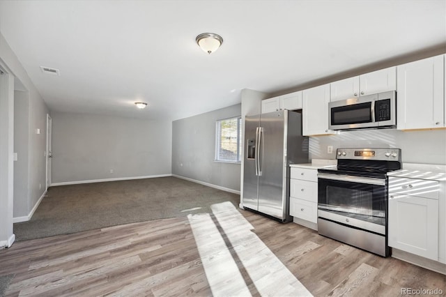3900 Turnpike Dr, Westminster, CO 80030 - kitchen featuring white cabinets, stainless steel appliances, baseboards, and visible vents