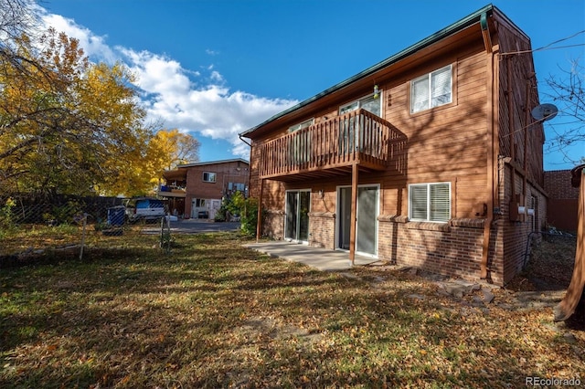 3900 Turnpike Dr, Westminster, CO 80030 - rear view of house with fence, brick siding, a patio area, a balcony, and a lawn