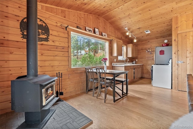 339 Hall Rd, Bailey, CO 80421 - dining area with vaulted ceiling, wood ceiling, a wood stove, wood walls, and light wood finished floors