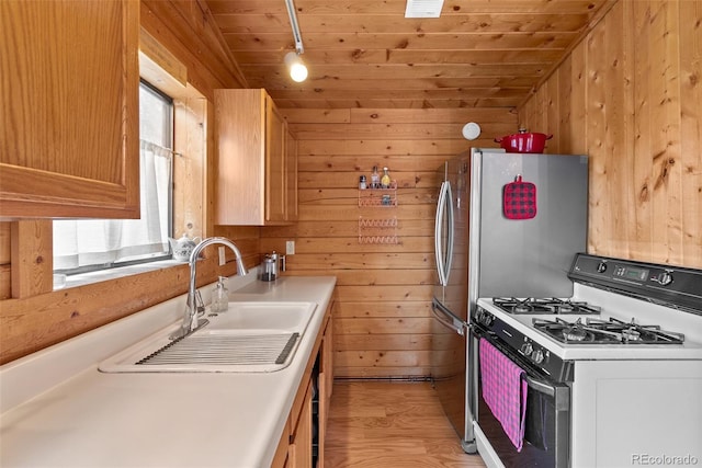 339 Hall Rd, Bailey, CO 80421 - kitchen with white gas range, wood walls, track lighting, healthy amount of natural light, and light wood finished floors