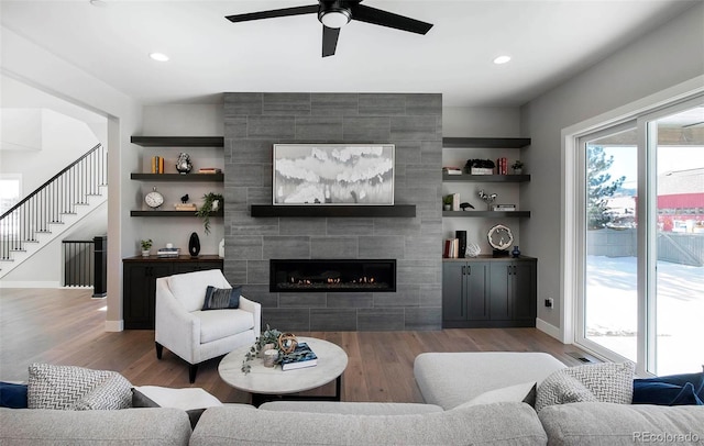 living room with dark wood-type flooring, a fireplace, and built in features