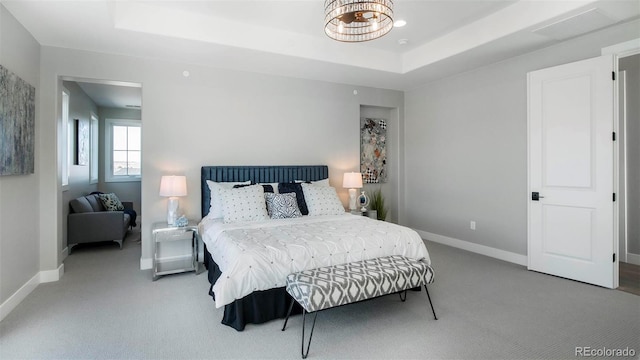 carpeted bedroom featuring a raised ceiling