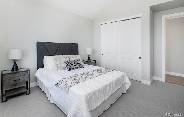 bedroom featuring lofted ceiling, light carpet, and a closet