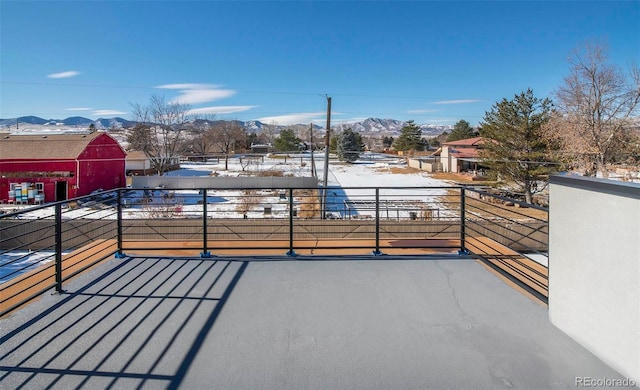 snow covered back of property with a mountain view