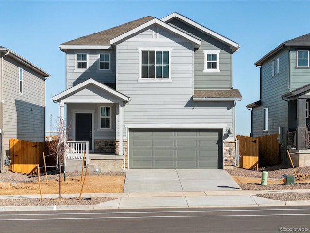 craftsman inspired home with stone siding, concrete driveway, an attached garage, and fence