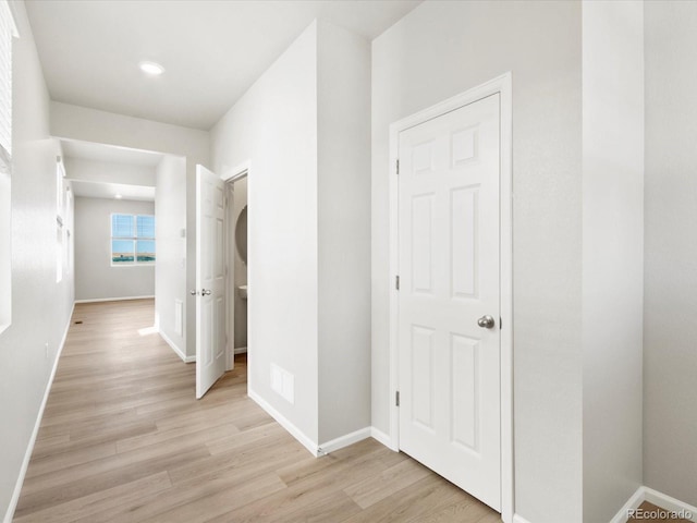 hall featuring baseboards and light wood-type flooring