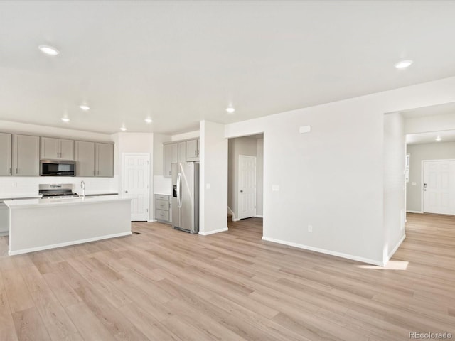 kitchen with gray cabinetry, recessed lighting, light wood-type flooring, and stainless steel appliances