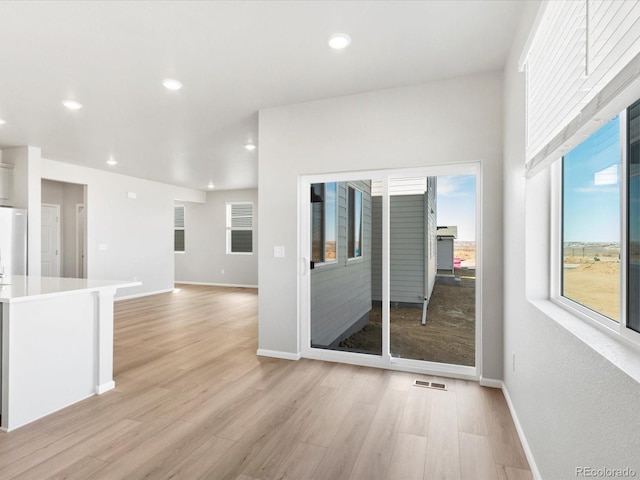 empty room with recessed lighting, visible vents, light wood finished floors, and baseboards