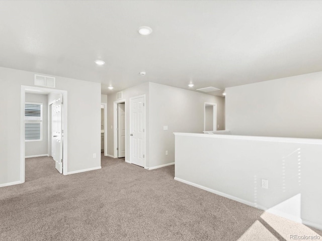 carpeted empty room featuring visible vents, recessed lighting, and baseboards