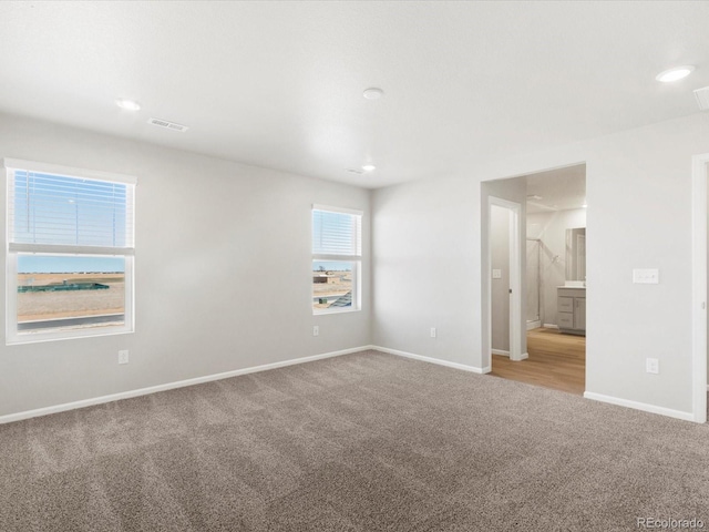 empty room with visible vents, recessed lighting, carpet, and baseboards