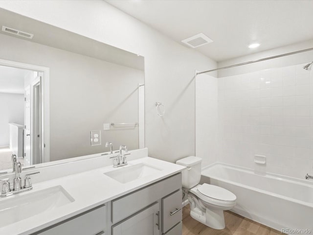 full bath with a sink, visible vents, toilet, and wood finished floors